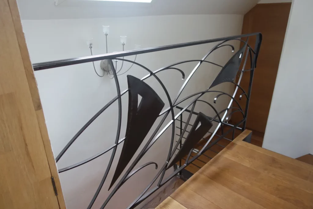 Garde corps en fer forgé avec des motifs en metal evoquant des voiles